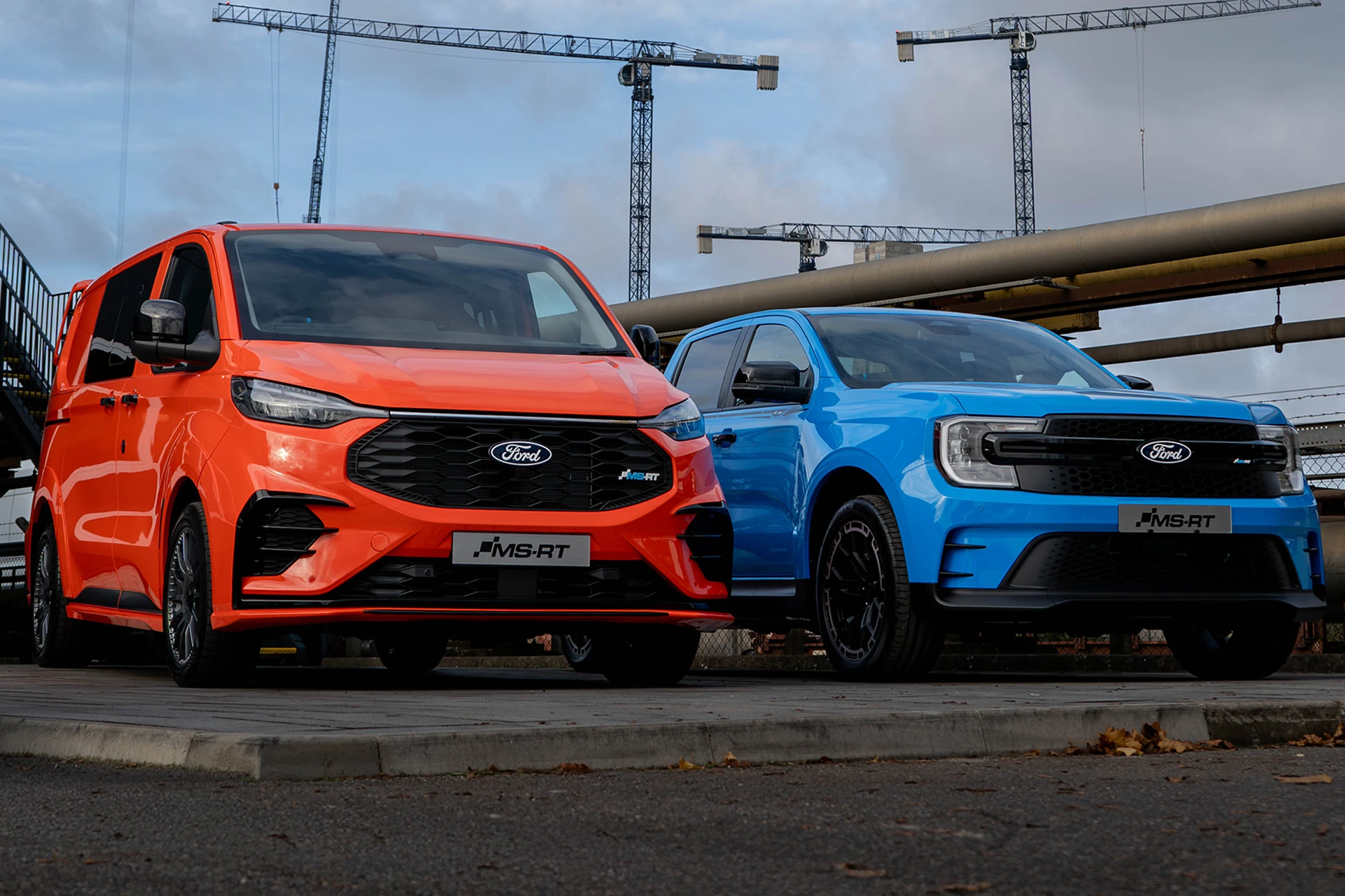 a sunset orange Ford Transit Custom MS-RT and a fast blue Ford Ranger MS-RT at a work site